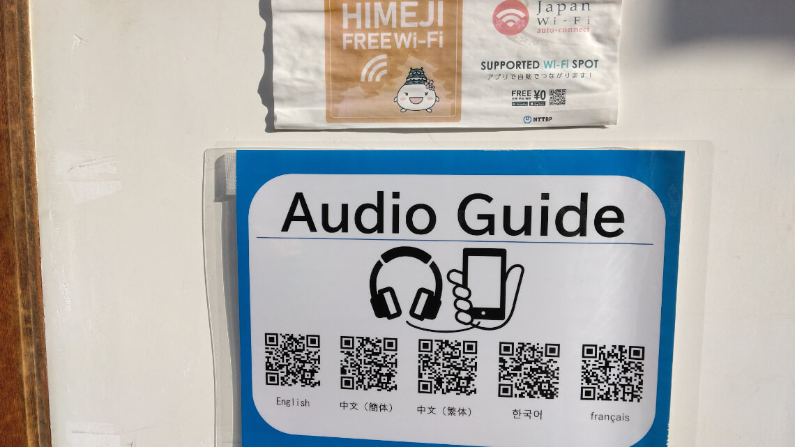 Signs offering free Wi-Fi and an audio guide with QR codes for multiple languages, including English, Chinese, Korean, and French.