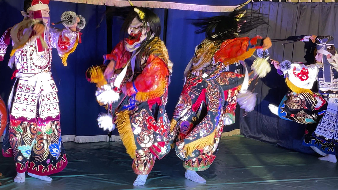 Performers dancing wearing warrior and demon costumes made from Japanese paper