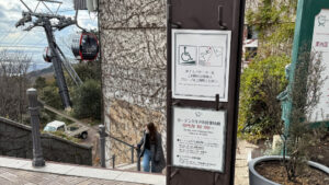 Accessibility sign advises wheelchair and stroller users to use the slope, giving directions.
