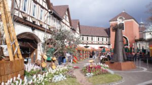 Plaza at the top of the Kobe Nunobiki Herb Gardens ropeway, featuring Tudor-style buildings and flower beds.