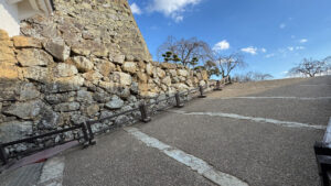 A steeper gravel path further into the castle grounds, with wooden railings for support.