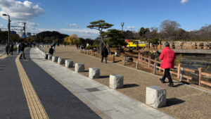 A pathway with tactile paving and stone blocks leads to the castle park. Inside, pathways lack tactile paving.