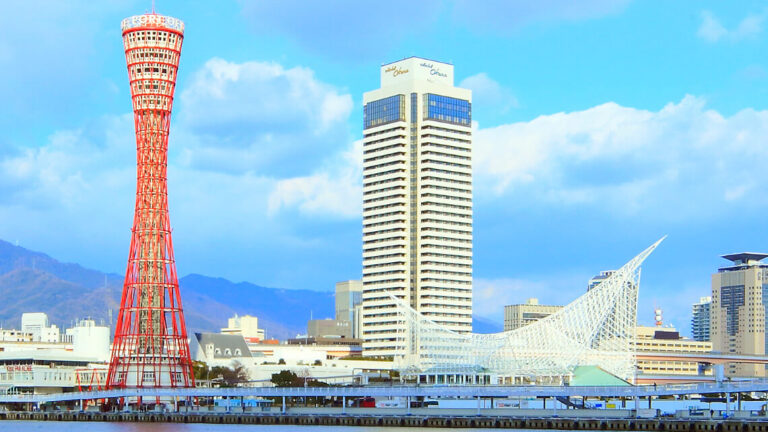 Hotel Okura Kobe stands as a tall, modern building next to the red Kobe Port Tower and the white, angular Kobe Maritime Museum, with a clear sky above. Hotel Okura Kobe stands as a tall, modern building next to the red Kobe Port Tower and the white, angular Kobe Maritime Museum, with a clear sky above.