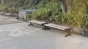 Wooden benches located along a smooth pathway, providing a resting spot midway through the garden route.